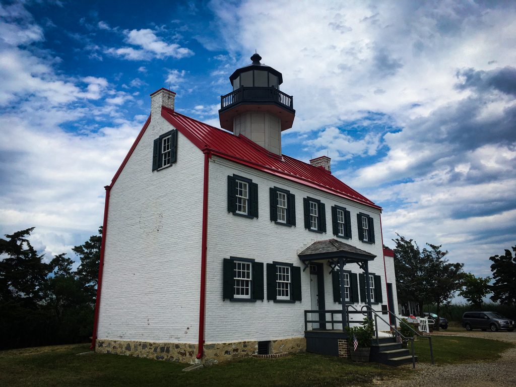 lighthouse with red roof and blue skies